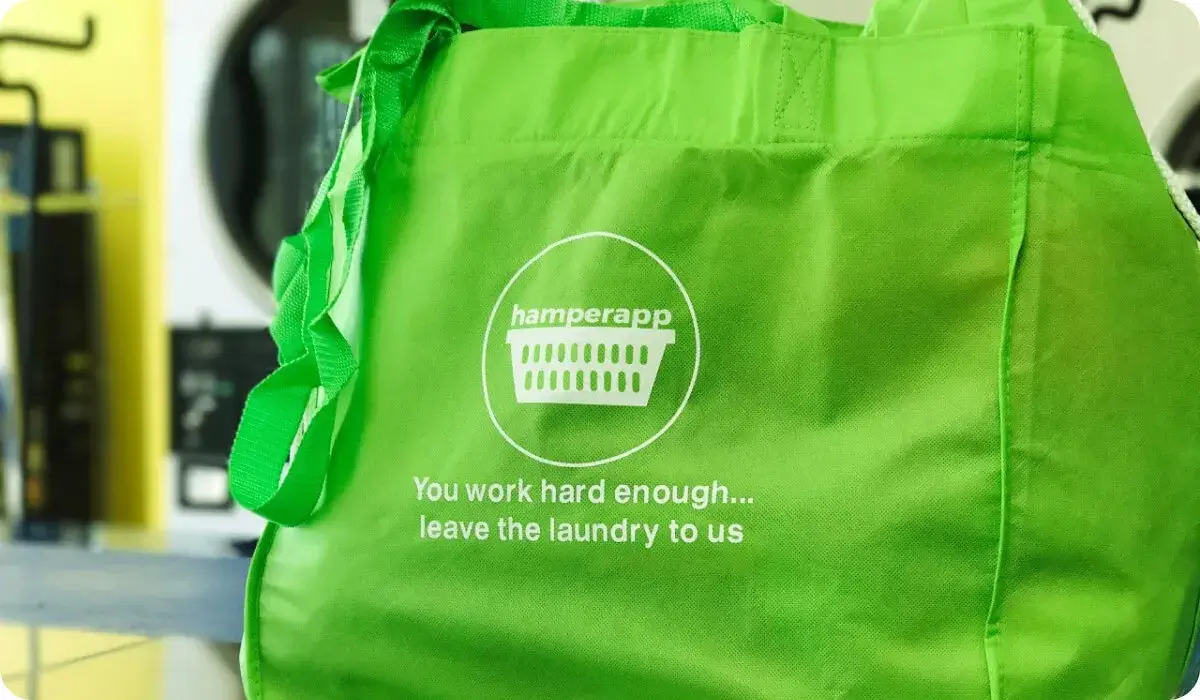A green Hamperapp laundry bag, packed and ready for pickup